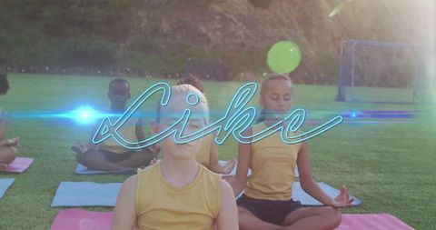 Children meditating outdoors on yoga mats in sports field