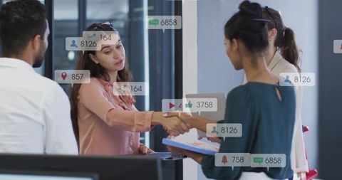 Businesswomen shaking hands with social media overlay showing networking and collaboration