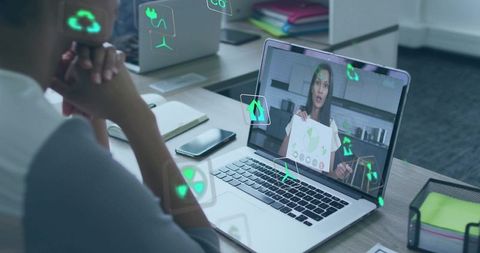 Remote presenter showing sustainability chart on laptop with ar icons in team meeting