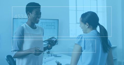 Businesswomen Collaborating on Digital Tablet in Modern Office Environment