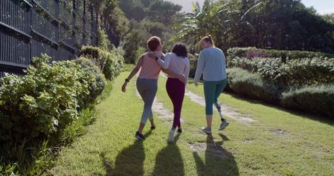 Diverse Women Walking Together in Vibrant Outdoor Garden Path