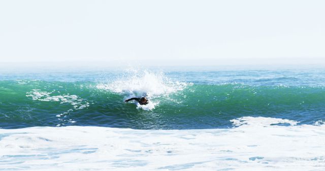 A surfer catches a wave, showcasing their skill and balance on the ocean's surface, with copy space. Surfing is a popular water sport that combines athleticism and an appreciation for the natural power of the sea.