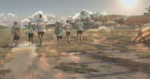 Children Jogging with Coach Across Sunlit Sports Field