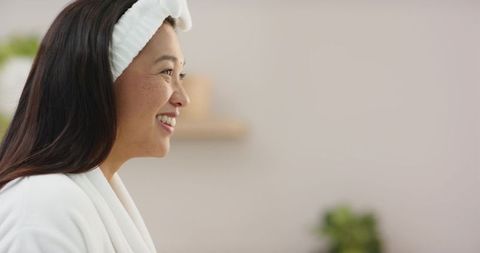 Smiling woman in bathrobe enjoying relaxation in spa-like bathroom