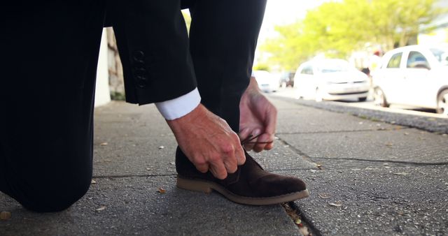 Man in Suit Tying Shoe on Urban Sidewalk on Bright Day Outdoors - Download Free Stock Images Pikwizard.com