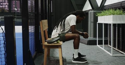 Exhausted athlete reflecting after padel match on indoor court