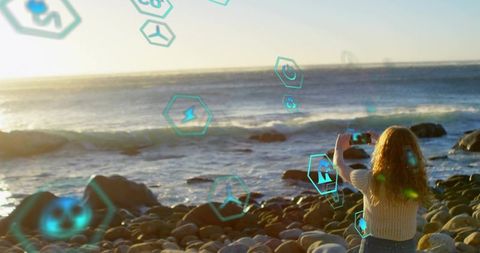 Woman Using Augmented Reality on Smartphone at Scenic Beach Sunset