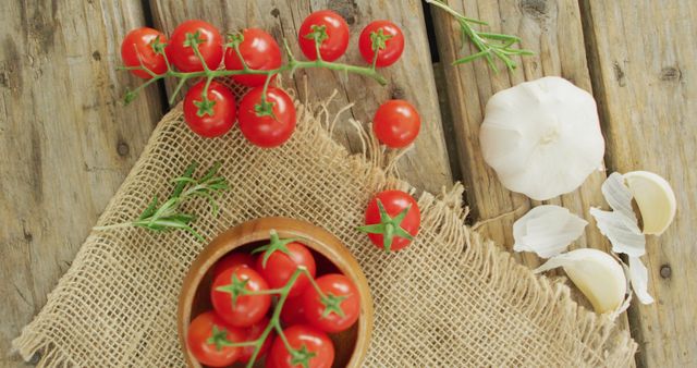 Image of fresh cherry tomatoes in bowl and garlic on rustic cloth over wooden background - Download Free Stock Photos Pikwizard.com