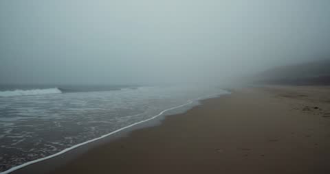 Misty Beach with Gentle Waves in Ethereal Morning Light