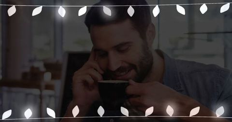 Man Enjoying Coffee While Talking on Smartphone in Cafe