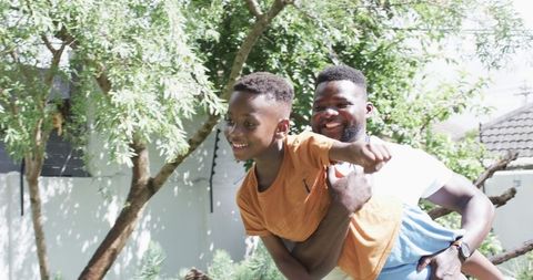 Father and Son Playing Outdoors in Sunny Garden