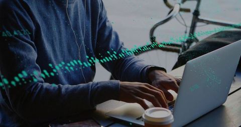 Typing on laptop in coffeehouse, working remotely with headphones and data waveform