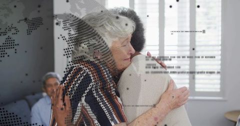 Senior Women Embracing for Comfort and Support at Home with Subtle Digital Overlay