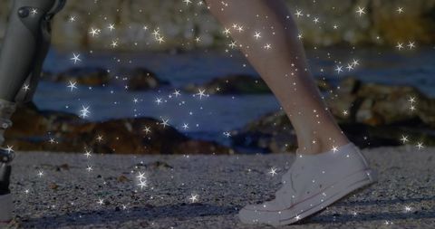 Walking on pebble beach showing prosthetic leg and white sneaker with sparkles