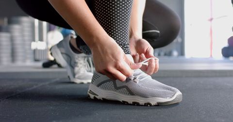 Woman Tying Shoelaces in Gym Ready for Workout - Download Free Stock Images Pikwizard.com