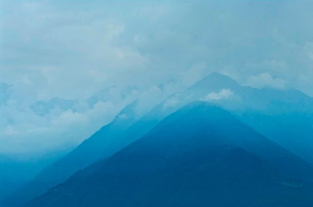 Misty Blue Mountain Peaks Against Cloudy Sky - Download Free Stock Photos Pikwizard.com