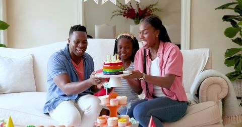 Family Celebrating Birthday with Colorful Cake at Home