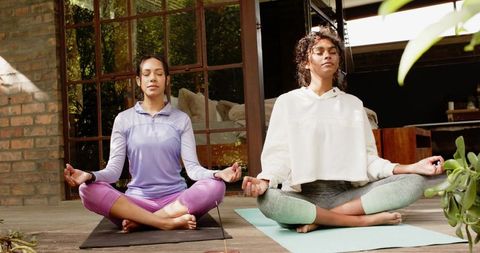 Women Meditating Outdoors on Yoga Mats Promoting Wellness and Serenity