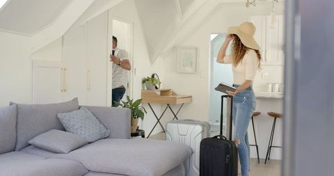 Couple Arranging Suitcases in Stylish Loft for Vacation