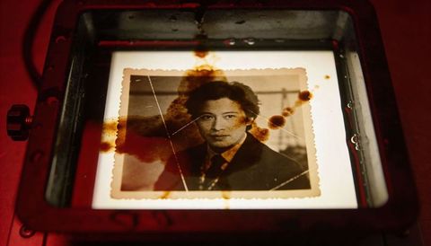 Damaged vintage portrait on lightbox with sepia stains, watermarks and film scratches