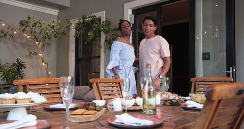 Couple Preparing for Romantic Celebration Dinner Outdoors