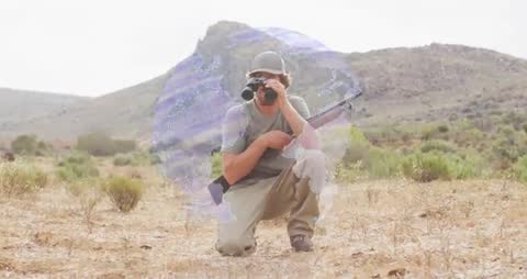 Explorer Using Binoculars in Wildernes with Floating Digital Earth Map