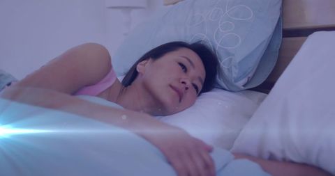 Asian Woman Lying in Bed Amidst Soothing Light