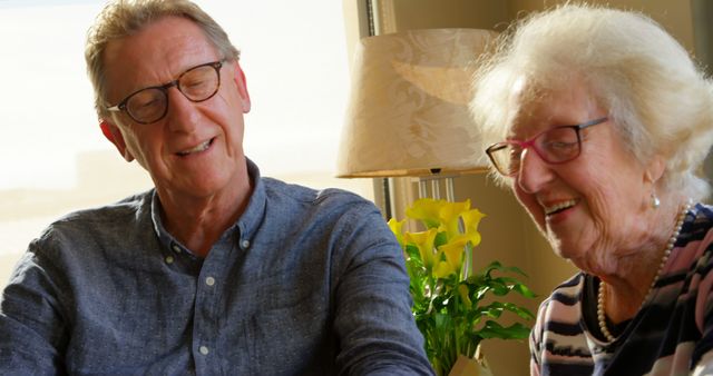 Senior man and elderly woman enjoying conversation in cozy living room - Download Free Stock Images Pikwizard.com