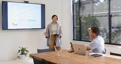 Business Meeting Presentation in Modern Office with Tables and Tablets