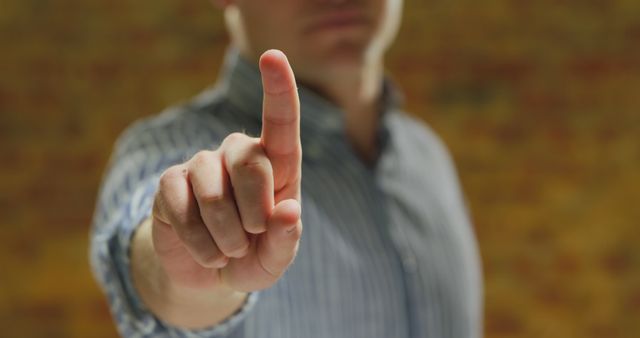 Caucasian man showing pointing hand in front of brick wall - Download Free Stock Photos Pikwizard.com