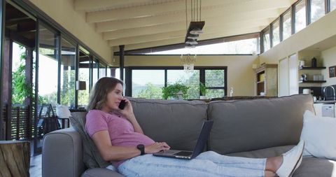 Pregnant Woman Relaxing on Sofa During Home Office Phone Call