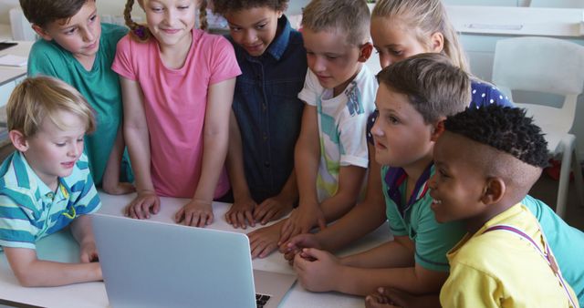 Happy diverse children using laptop together in elementary school classroom - Download Free Stock Photos Pikwizard.com