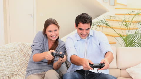 Couple Enjoying Video Game Session on Couch at Home