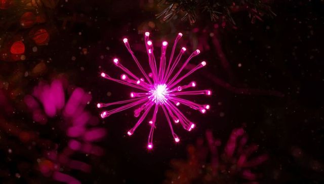 Glowing fiber optic pink star with festive bokeh lights