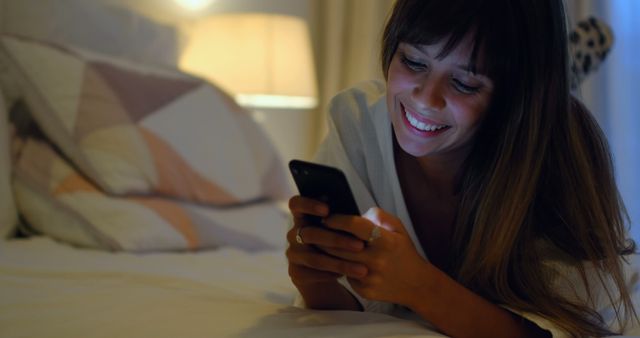 Woman Using Smartphone While Relaxing on Bed at Night - Download Free Stock Images Pikwizard.com