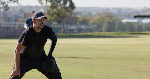 Amateur baseball player fielding on grass outfield wearing cap glove and compression sleeve