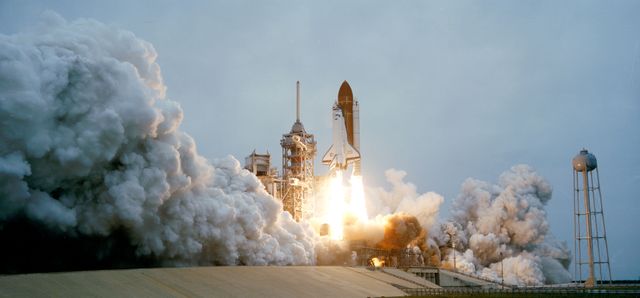 Space Shuttle Discovery launching from Kennedy Space Center on April 12, 1985. Suitable for articles, documentaries, educational purposes about space exploration and NASA missions. Highlights historical achievements in space travel and scientific experiments.