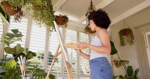 Focused Woman Painting on Canvas at Home Art Studio