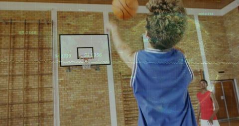 Youth basketball player shooting toward indoor hoop