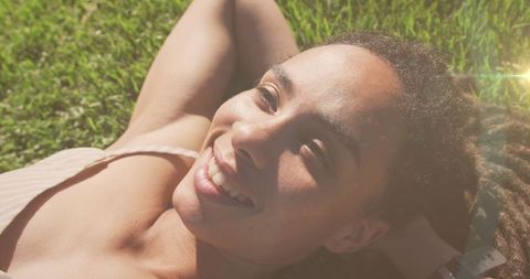 Joyful Woman Relaxing Outdoors in Sunlit Park