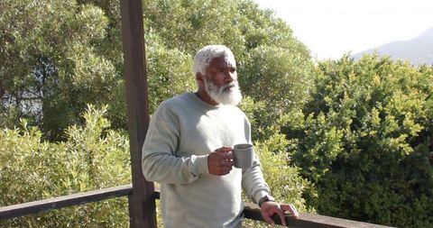 Senior Man Enjoying Morning Coffee on Tranquil Balcony