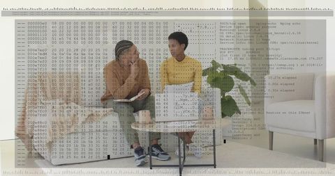 Discussing code while collaborating on laptop in modern living room