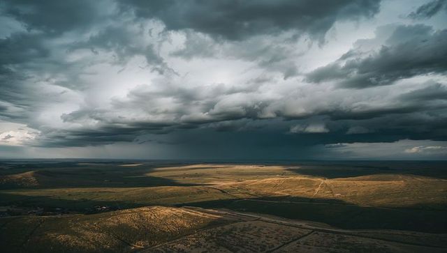 Cumulonimbus Cloud Rolling Over Sunlit Plains Casting Rain Shaft and Shadow