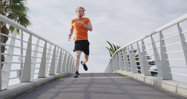 Blonde Man Running on Bridge for Fitness in Orange Shirt - Download Free Stock Images Pikwizard.com