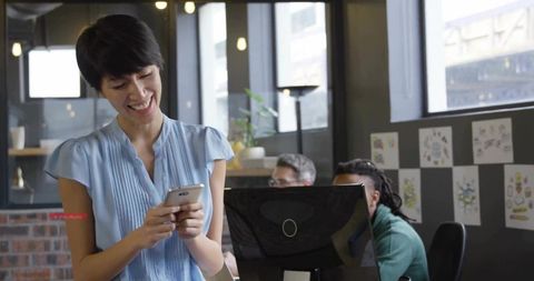 Office Worker Enjoys Using Smartphone in Modern Workplace