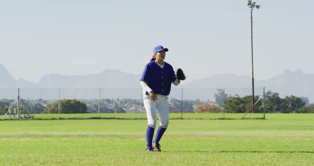 Caucasian female baseball player, fielder jumping, catching and throwing ball on baseball field. female baseball team, sports training and game tactics.