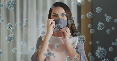 Woman adjusting face mask amid illustrated virus cells