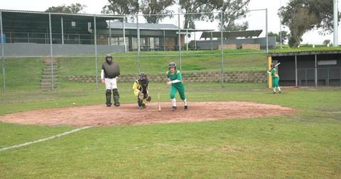Female softball player rounding home plate on field