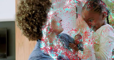 Hugging mother and daughter in cozy livingroom with turquoise glitter overlay