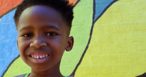 Cheerful African American Boy Posing Against Colorful Mural